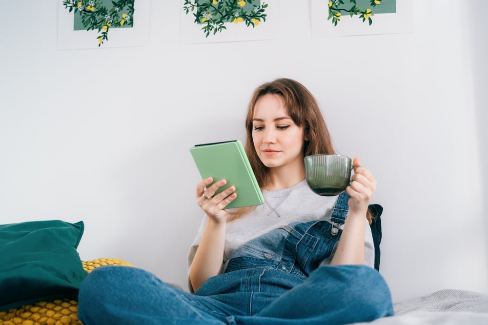 Young woman reading e-book on tablet reader in bed. 