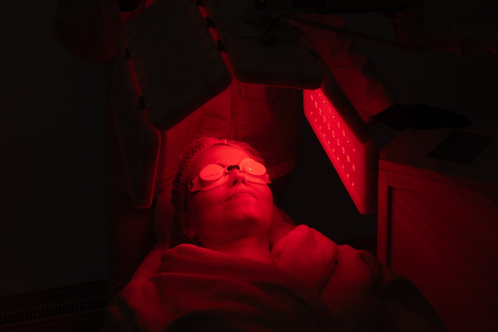 Relaxing facial treatment with red light therapy in a spa setting